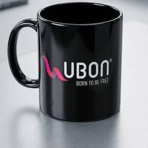 A glossy black ceramic coffee mug with custom corporate logo branding placed on an office desk